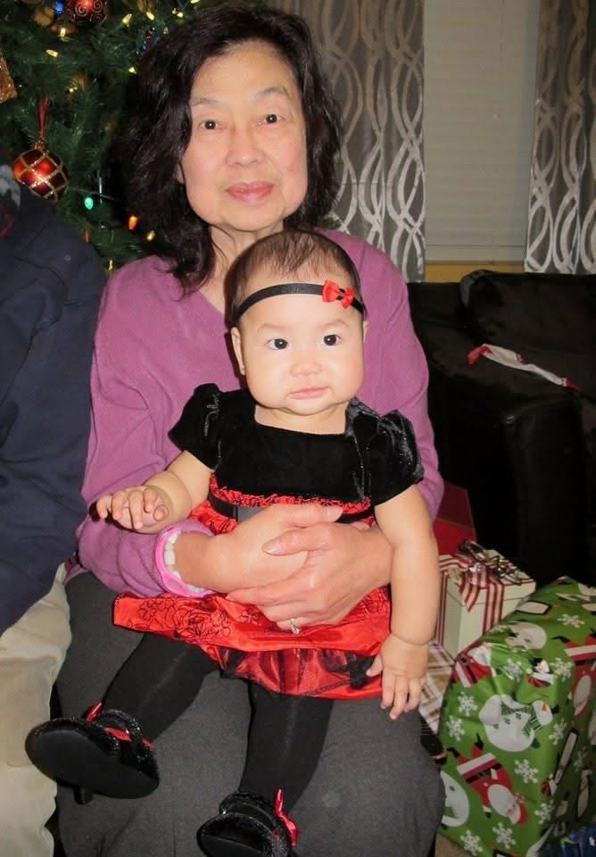Victoria holding a baby near a Christmas tree