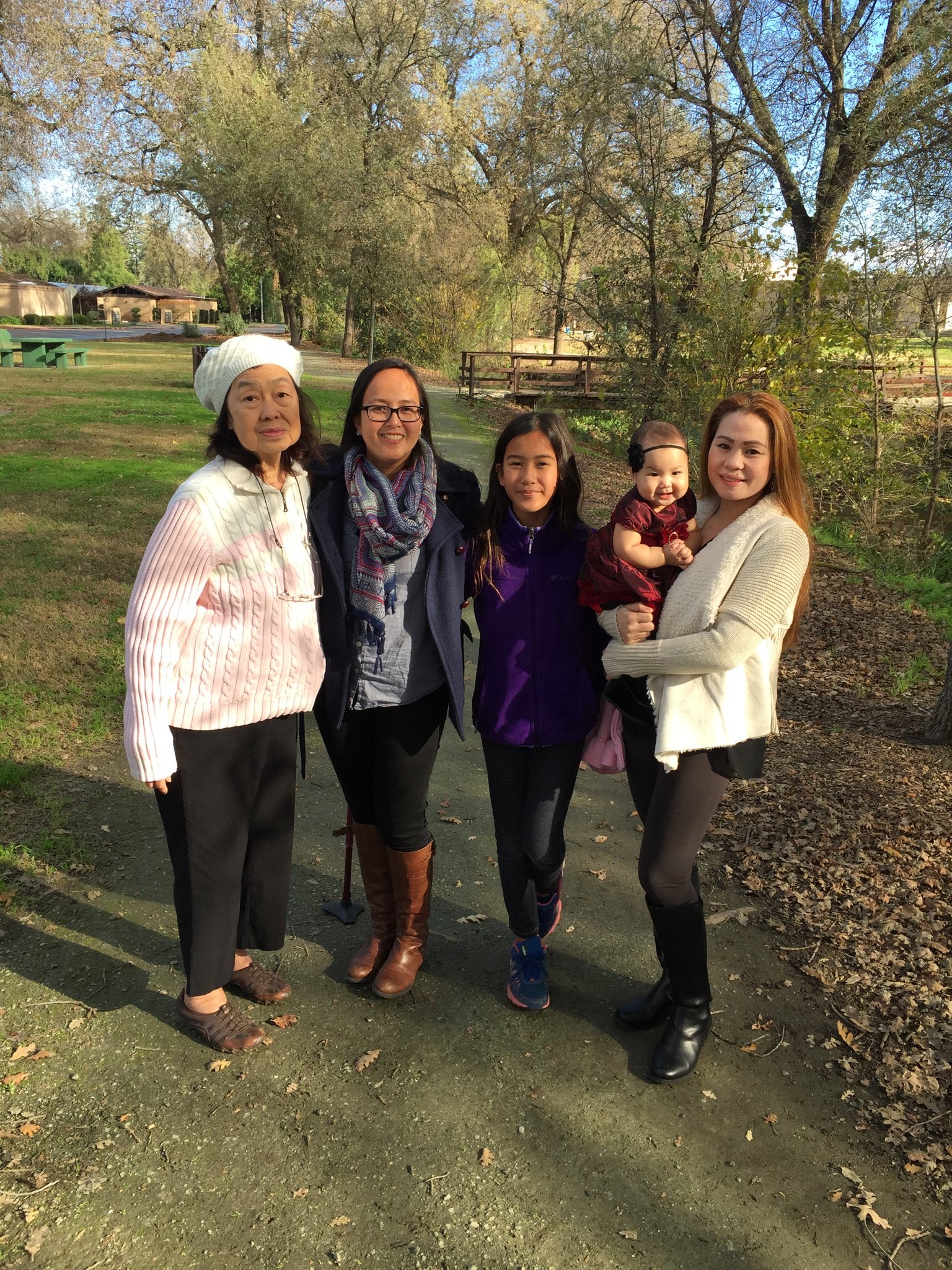 Multigenerational family standing together on an autumn park path