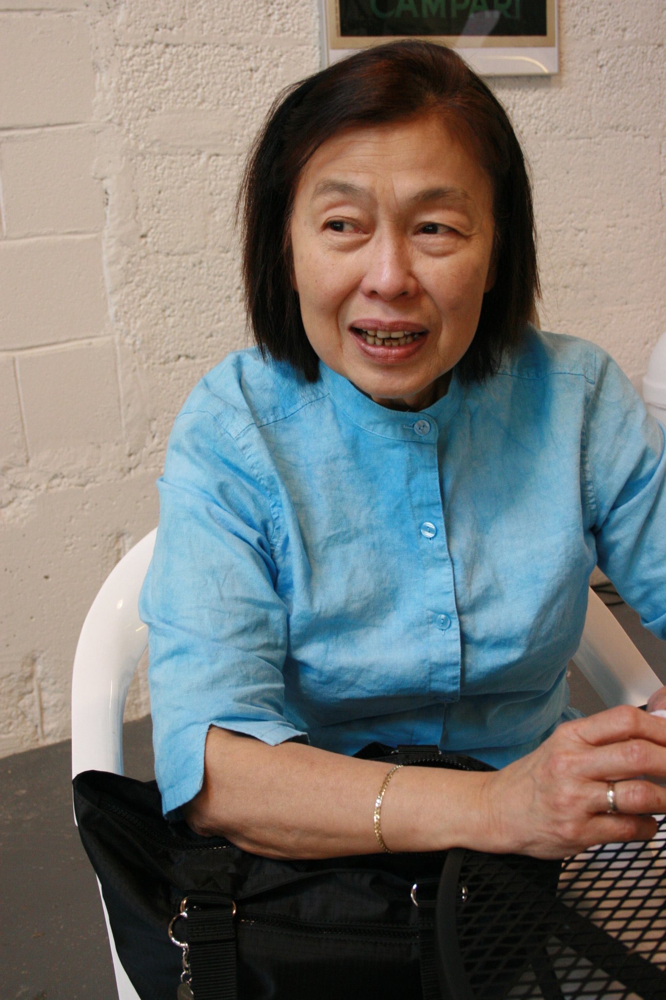 An older woman smiling warmly while seated at a table