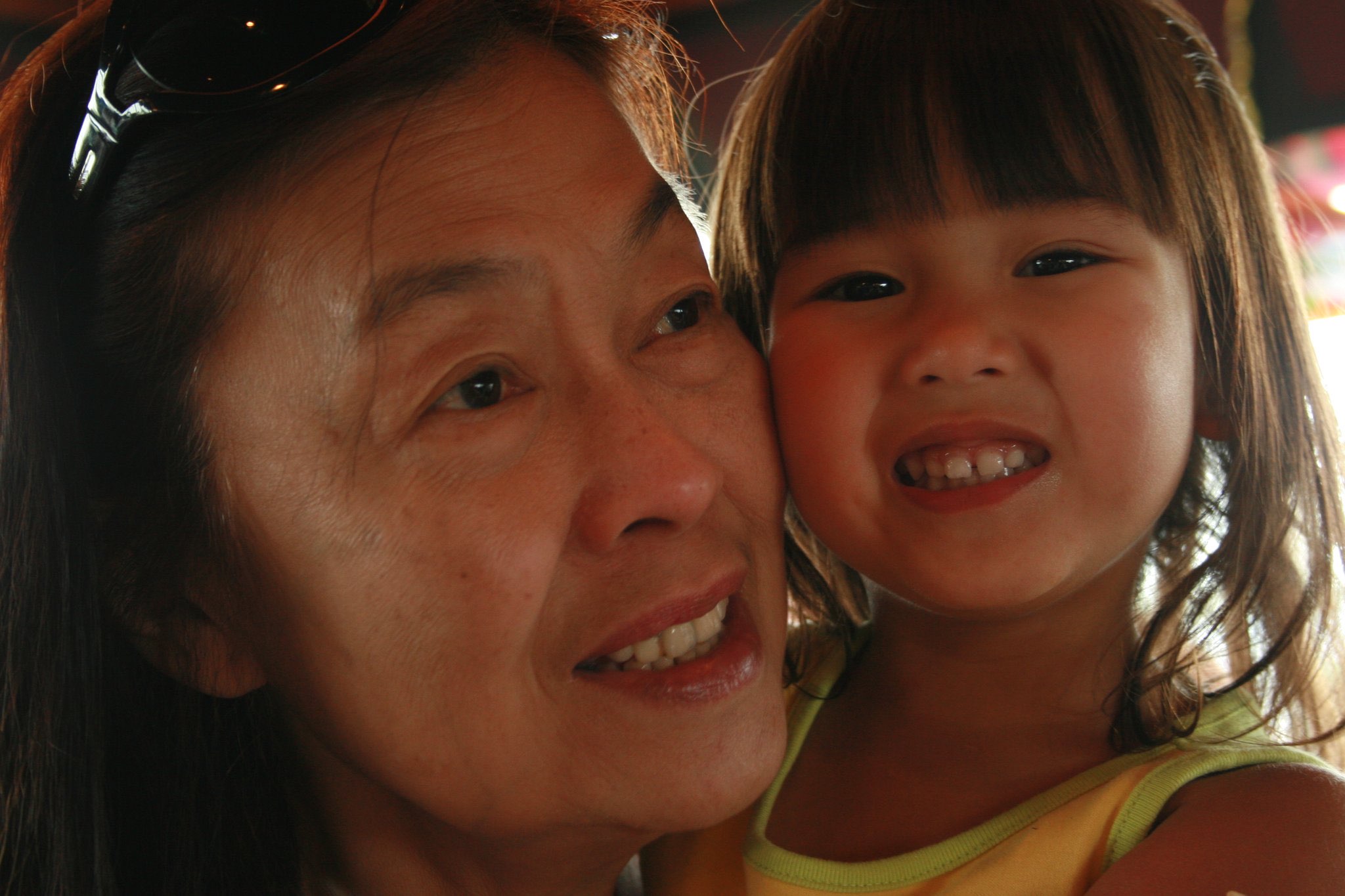 An older woman and young child smiling cheek to cheek