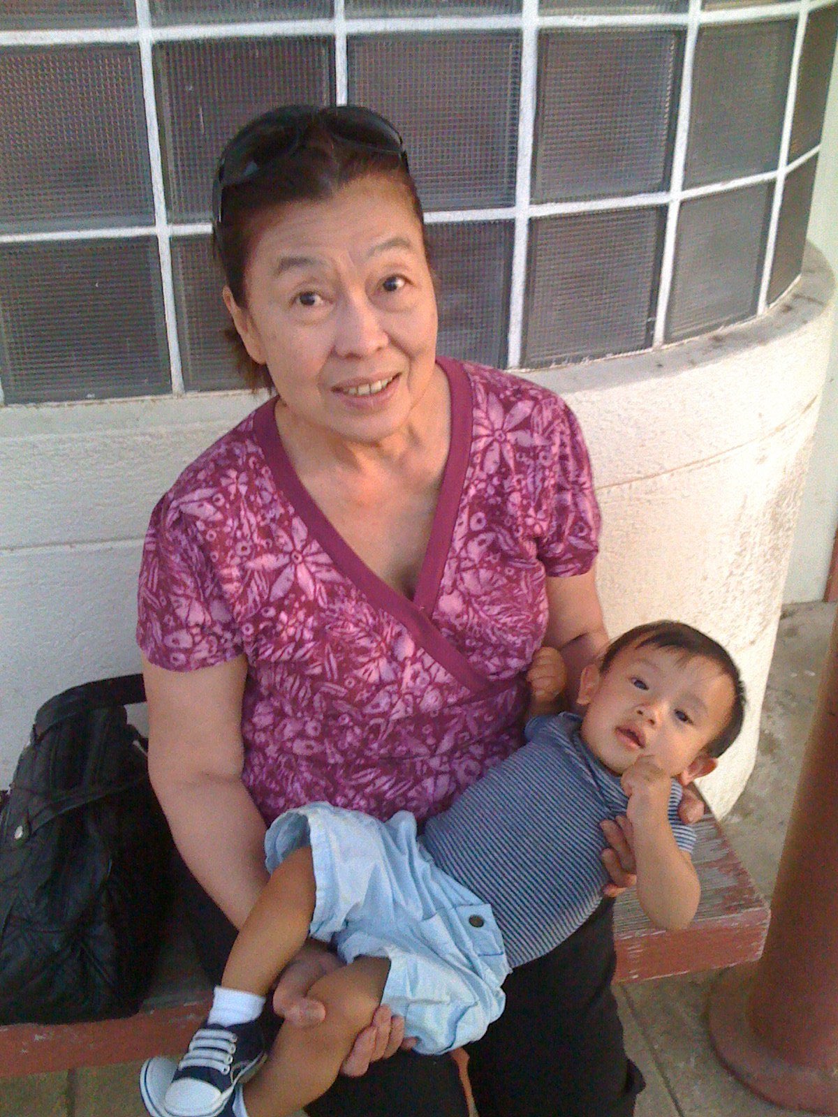 An older woman smiling with a toddler on her lap
