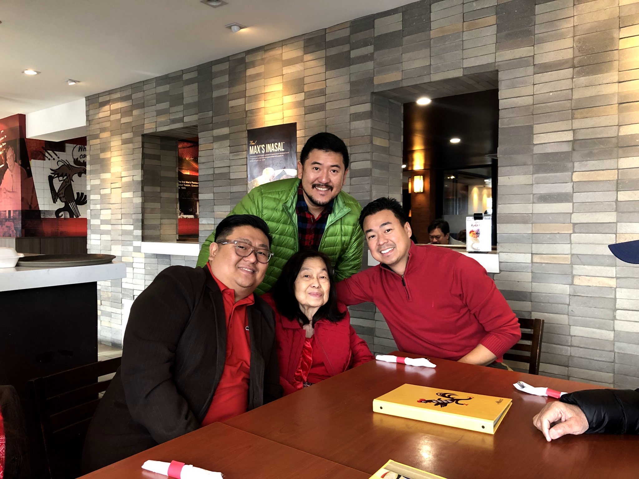Family smiling together around a restaurant table