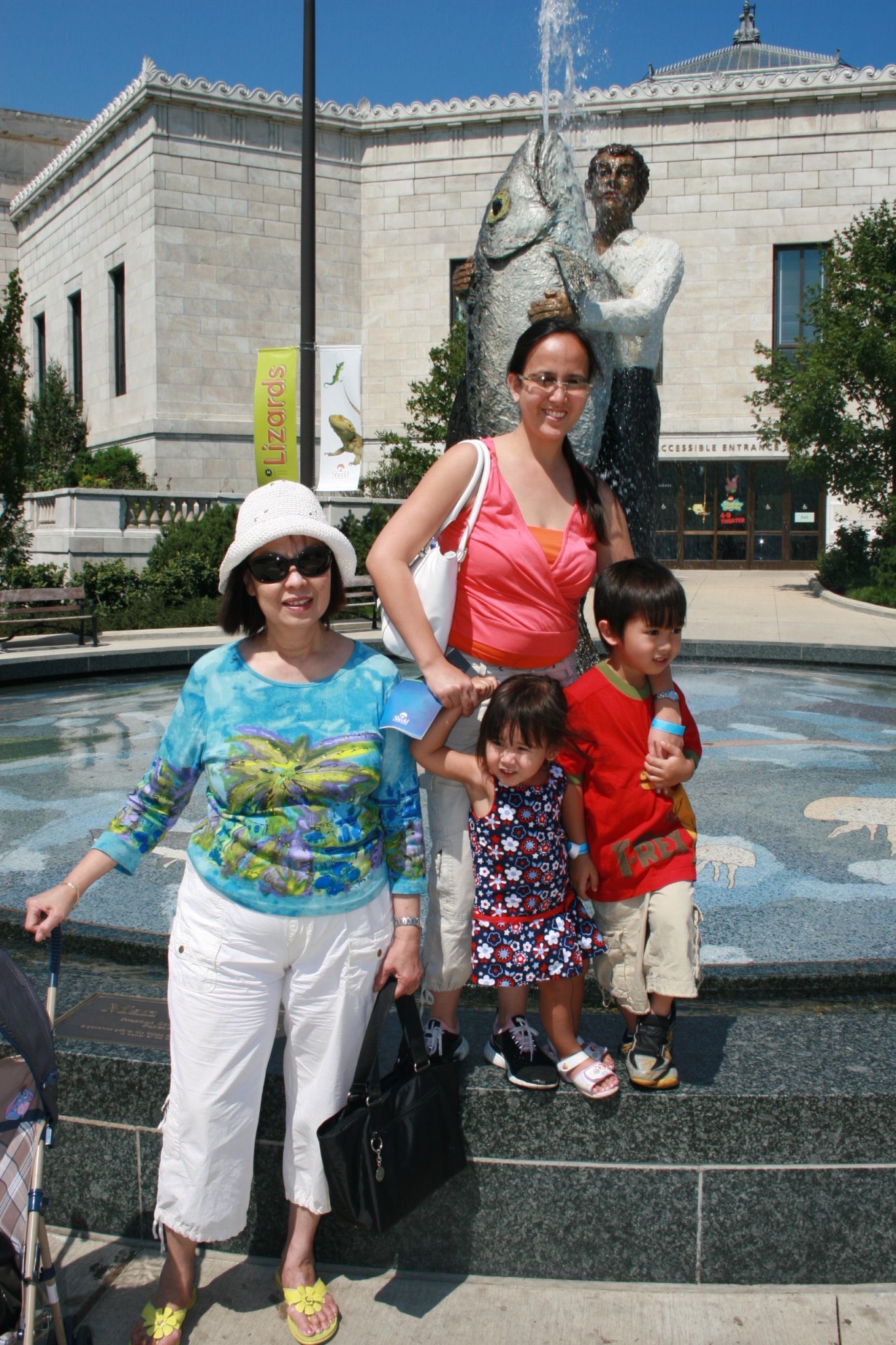 Family posing together outside the Shedd Aquarium on a sunny day