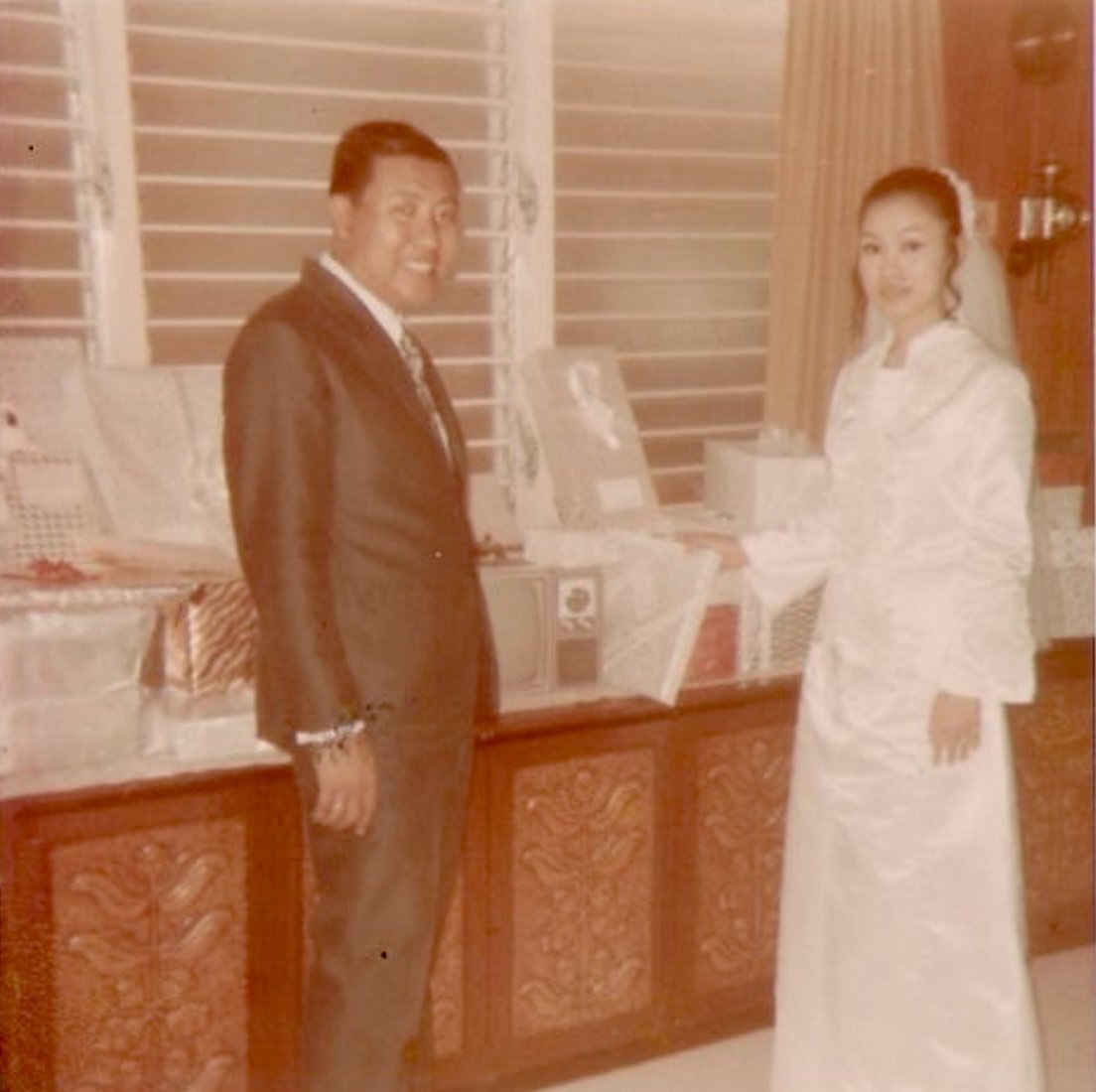 Vintage wedding day photo of a bride and groom standing together indoors
