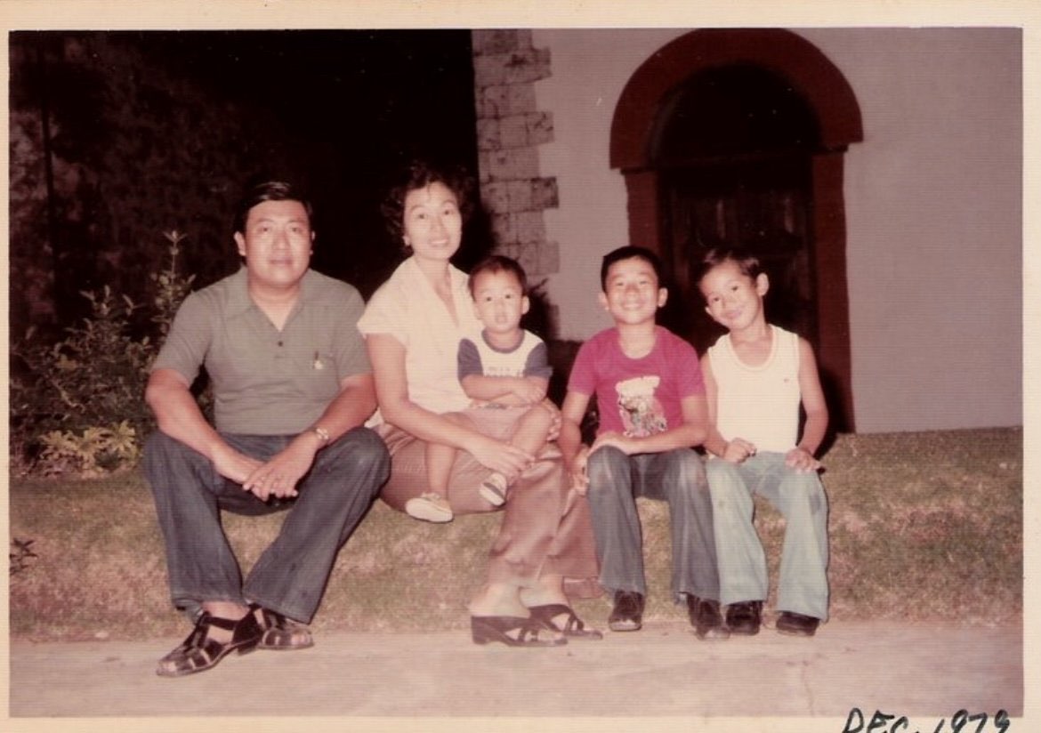 Vintage family photo seated outside a home, dated December 1973