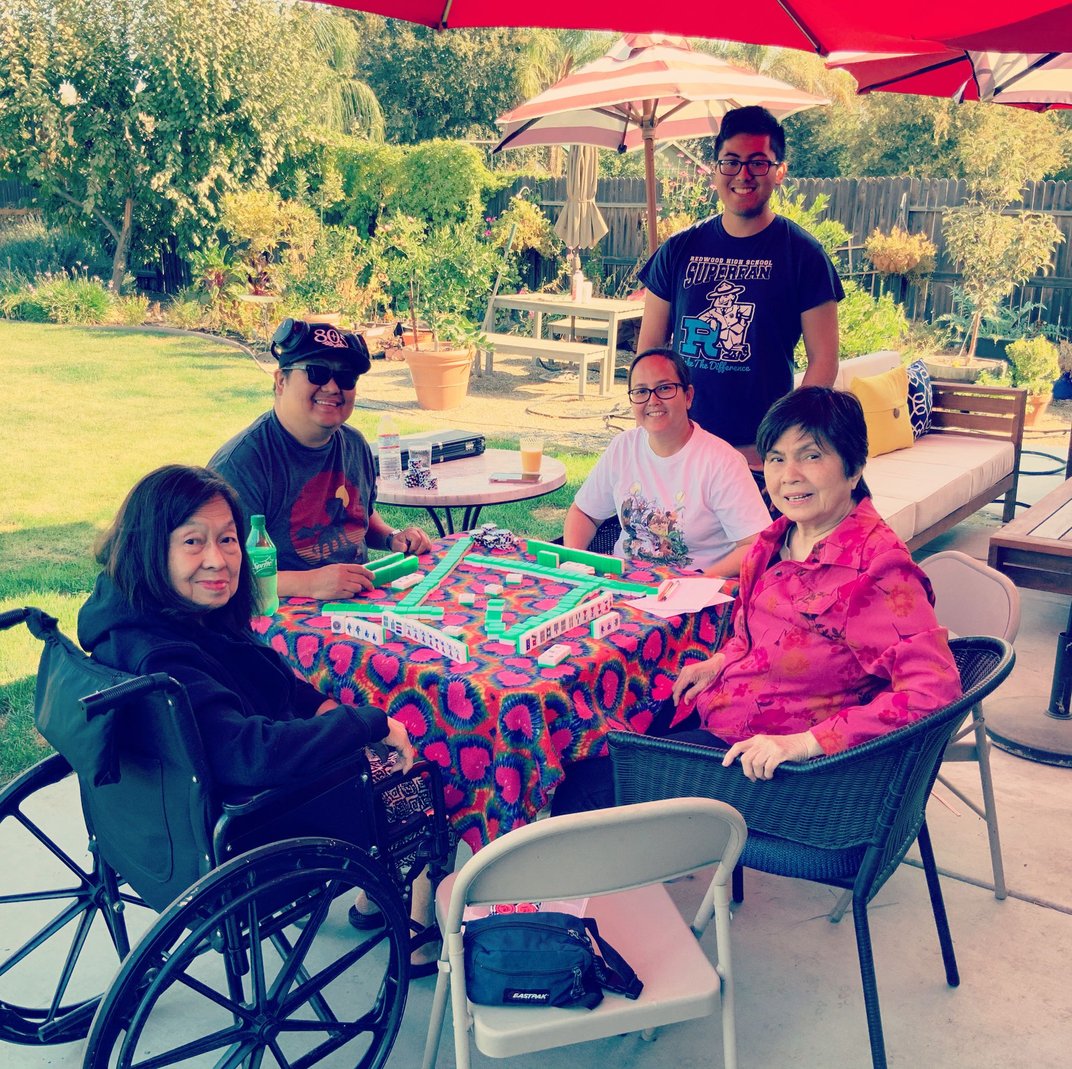 Family gathered outdoors around a Mahjong table