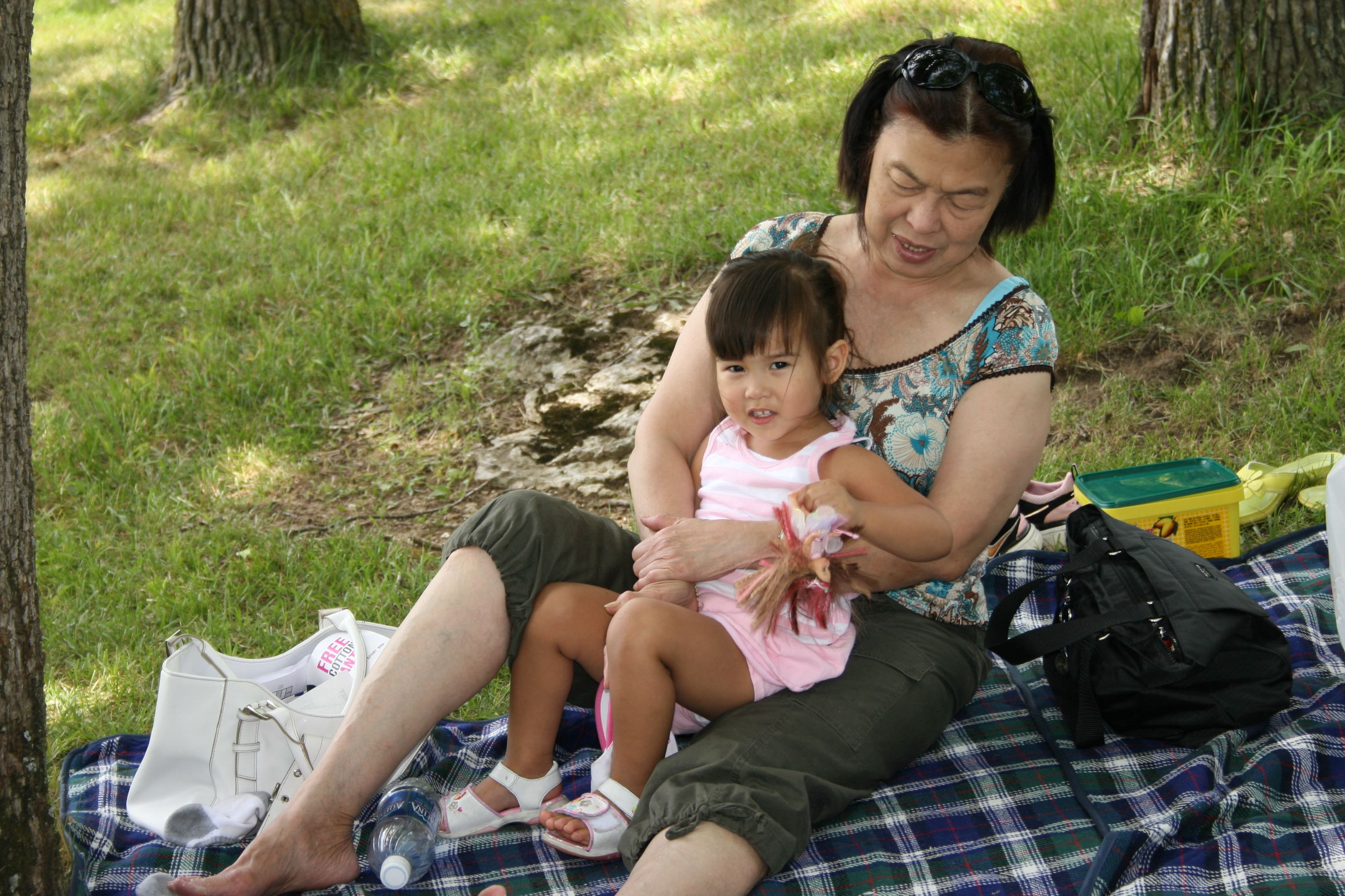 Outdoor family picnic moment with Victoria seated with a young child
